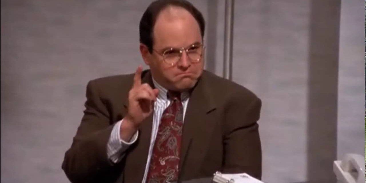 George pointing his finger at work on Seinfeld