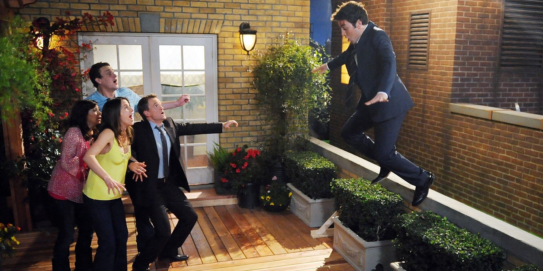 Ted leaps to the next door neighbour's patio with the gang in How I Met Your Mother