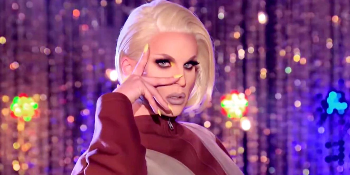 Katya poses on the runway with her hand at her face on RuPaul's Drag Race