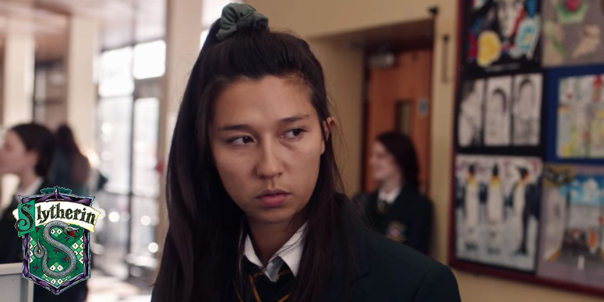 Mae in Derry Girls with a Hogwarts Slytherin  house crest in the lower left corner