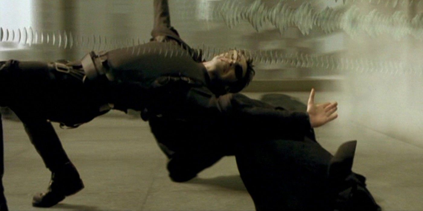 Keanu Reeves as Neo dodges bullets on the roof in The Matrix