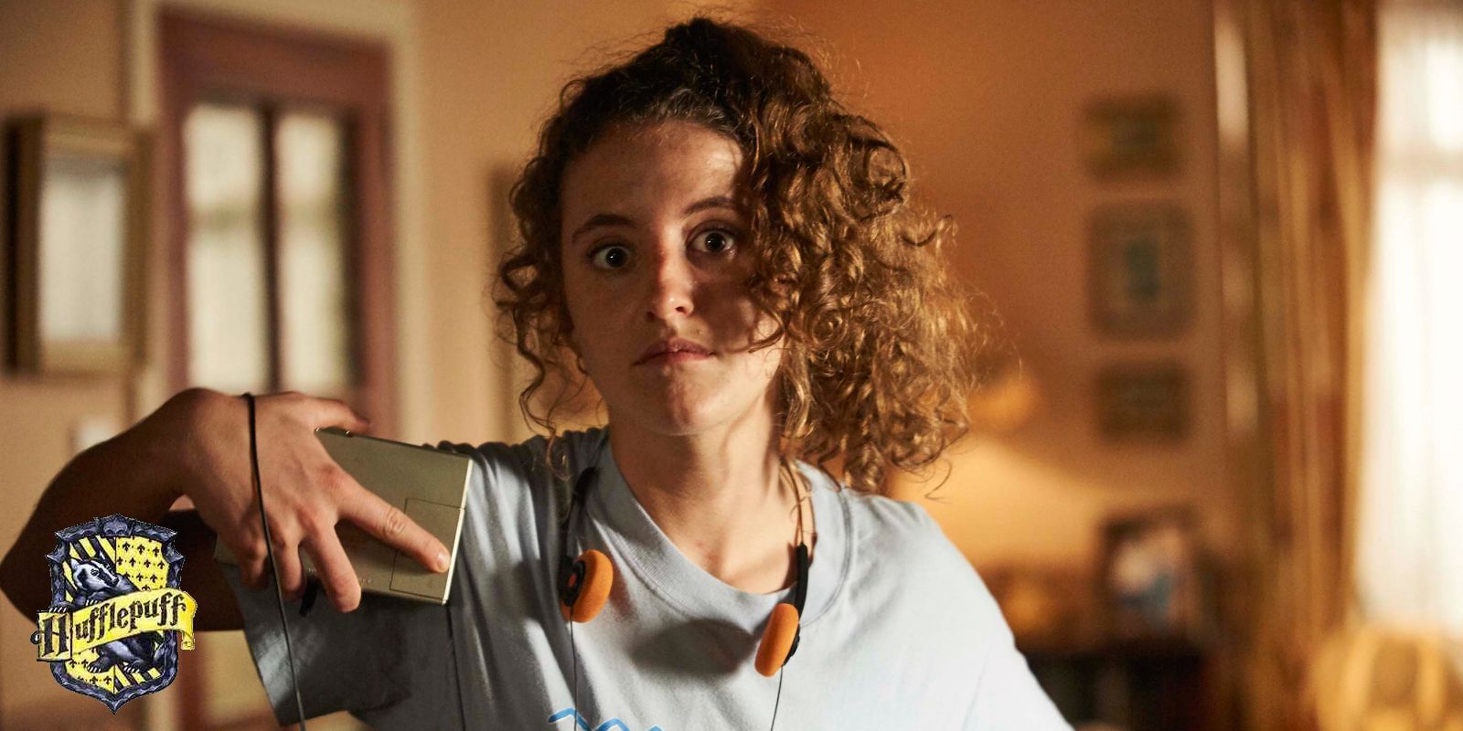 Orla in Derry Girls with a Hogwarts Hufflepuff house crest in the lower left corner