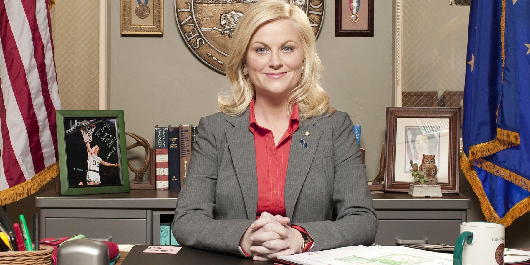 Amy Poehler folding hands on a table in a still from Parks and Recreation