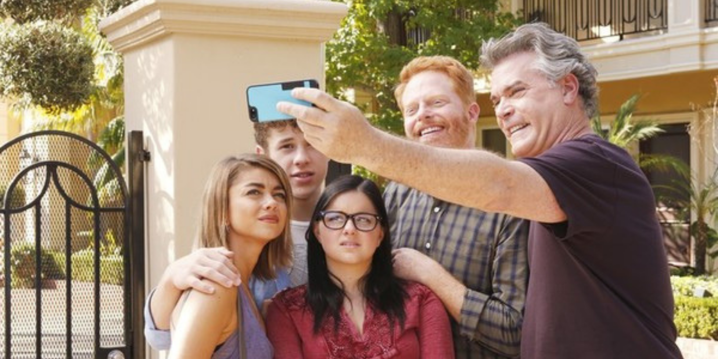 Mitch and the kids smiling with Ray Lotta on Modern Family