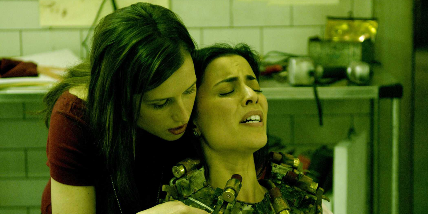 A woman putting a collar on another woman in Saw III