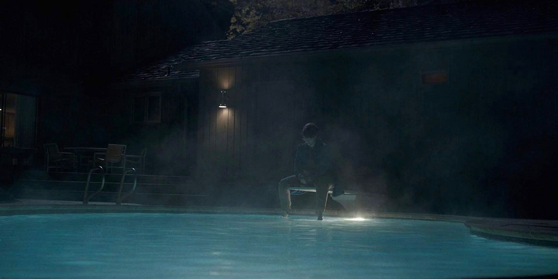 Shannon Purser as Barb in Stranger Things sitting on a diving board above a pool.