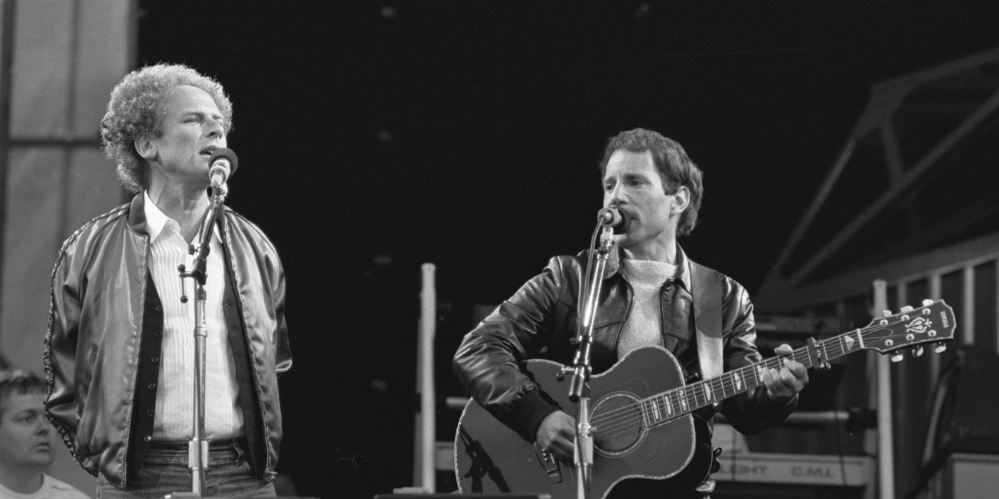 Simon and Garfunkel performing on stage in a black and white photo
