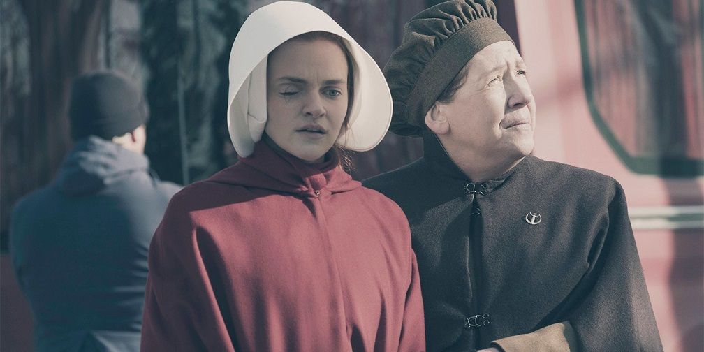 Janine standing with Aunt Lydia in her handmaid garb in a scene from The Handmaid's Tale