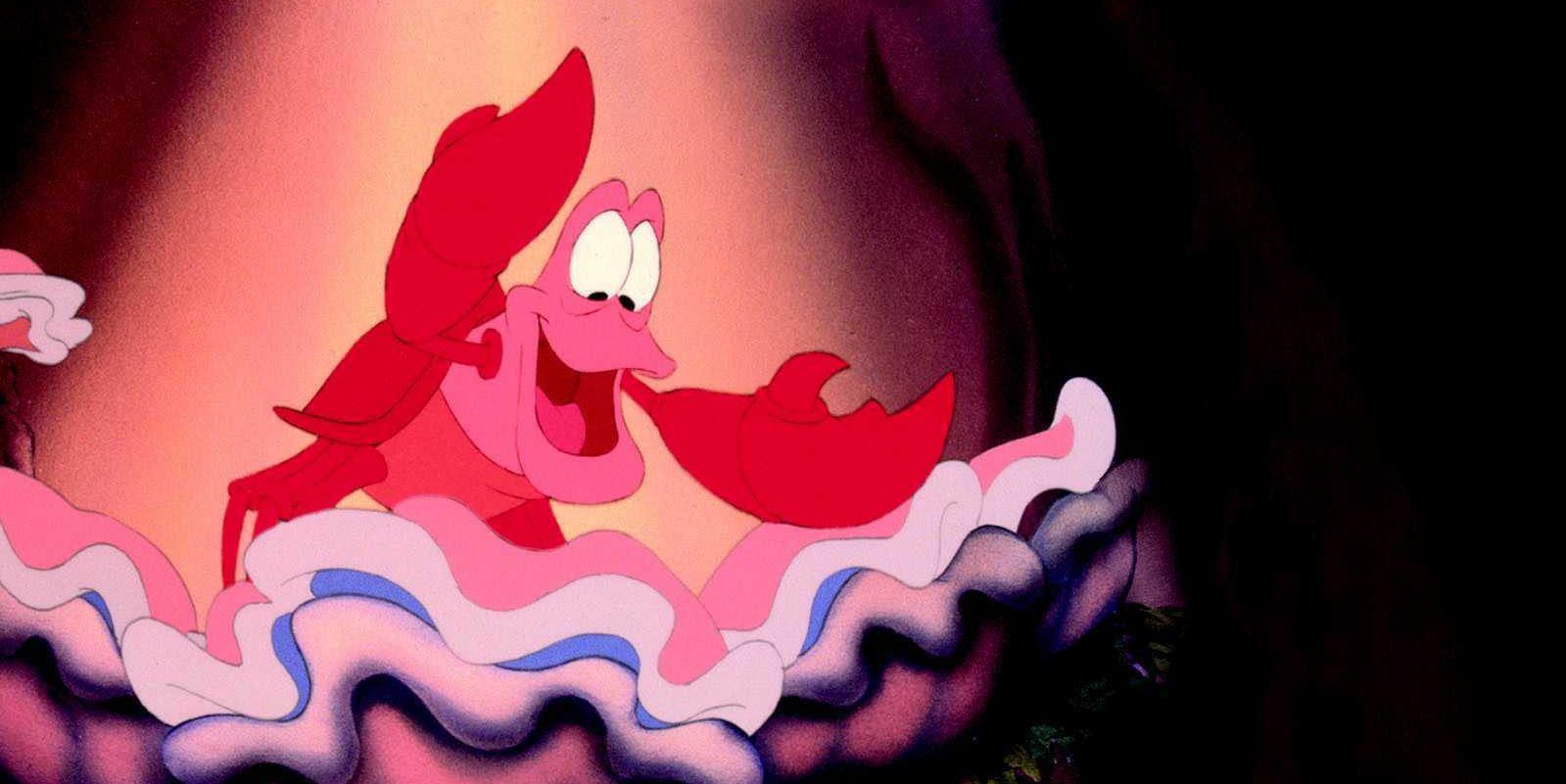 Sebastian in The Little Mermaid standing in a shell, smiling.