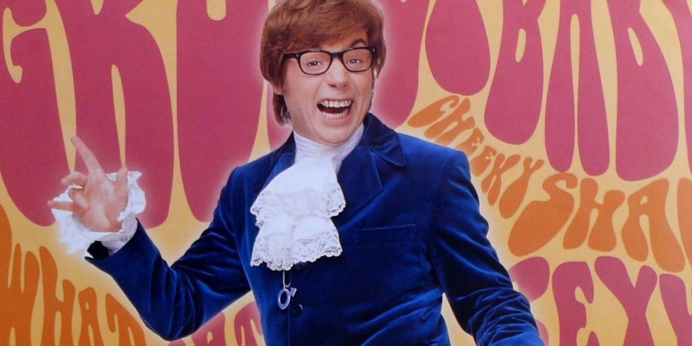 Austin Powers with his hand out in a blue suit and frilly white collar with the movie themed colors in the background.