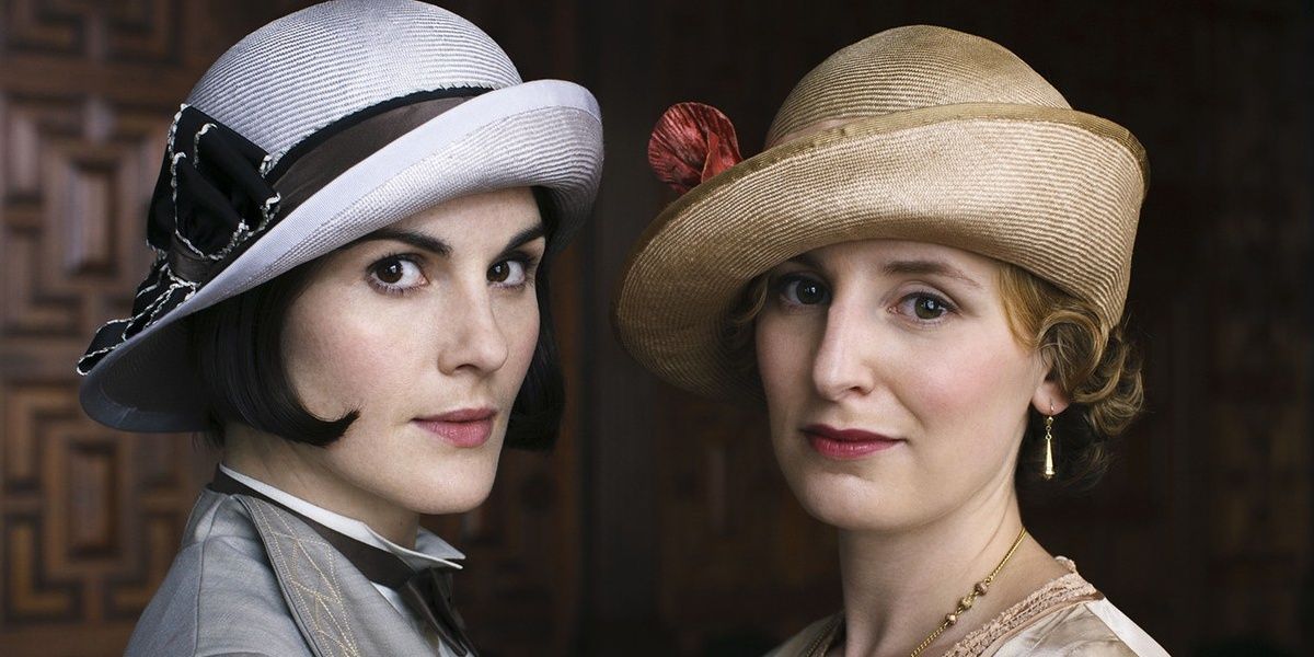 Mary and Edith stand facing each other in Downton Abbey.
