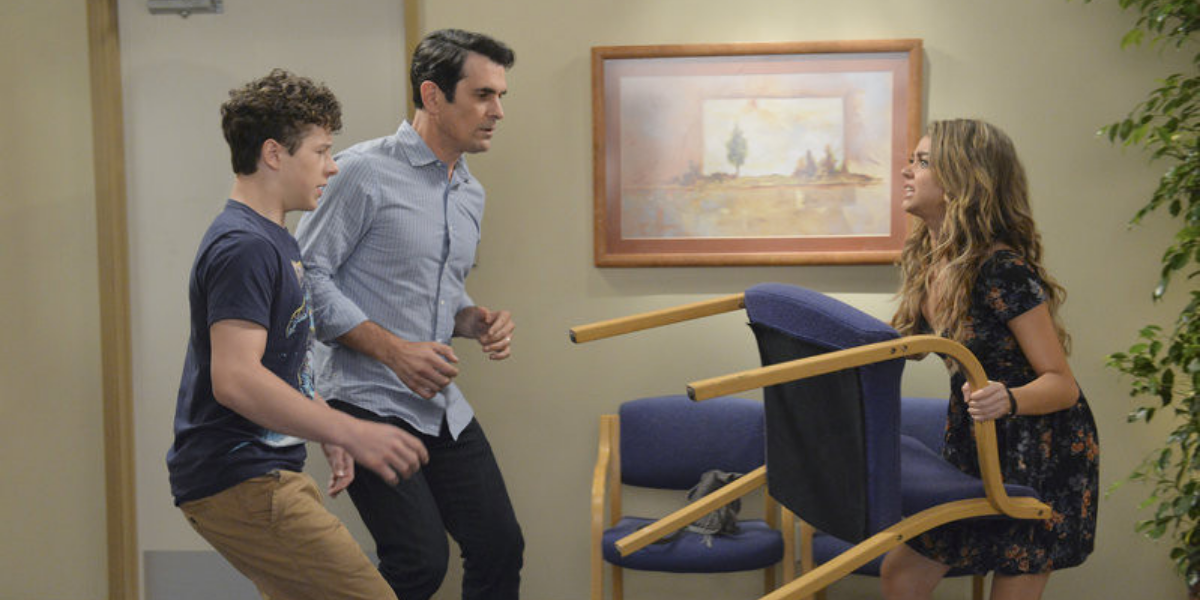 Haley attacking Phil and Luke with a chair on Modern Family