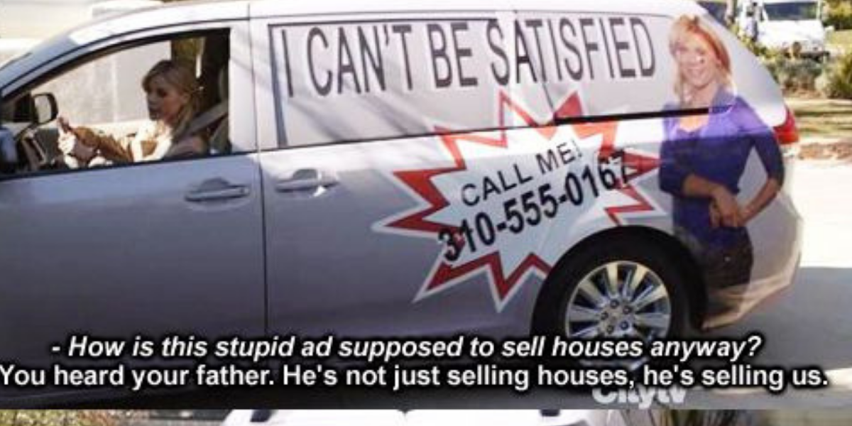 Claire driving an ad on her van on Modern Family