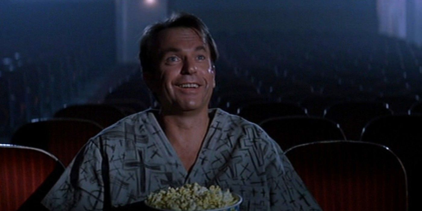 Sam Neill looking at a movie screen in In The Mouth Of Madness (1994)