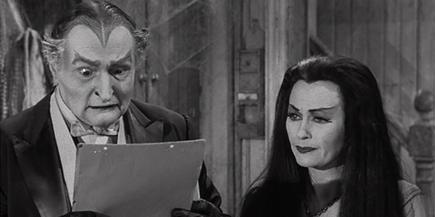 Grandpa looking worried while Lily smiles in a still from The Munsters