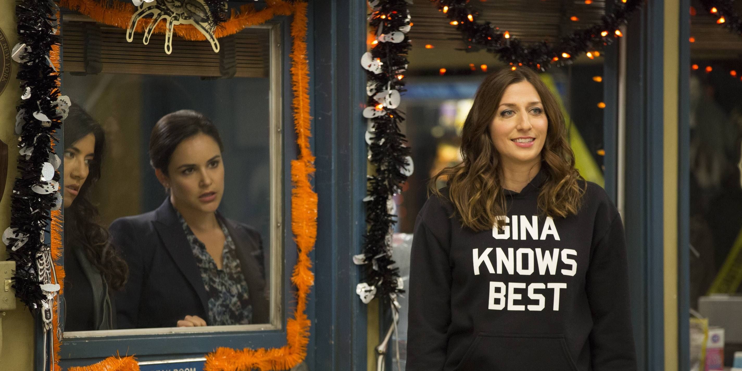 Amy and Rosa look at Gina from behind a door in Brooklyn 99