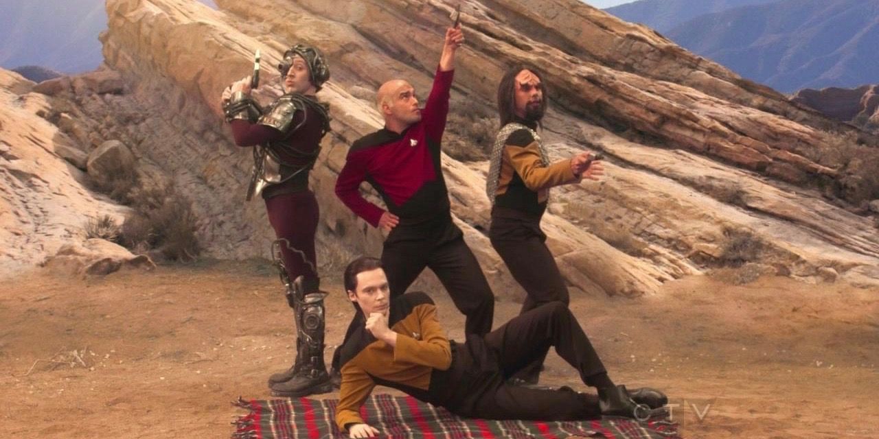 Howard, Leonard, Raj, and Sheldon dressed up as Star Trek characters, posing for a picture in the desert in The Big Bang Theory