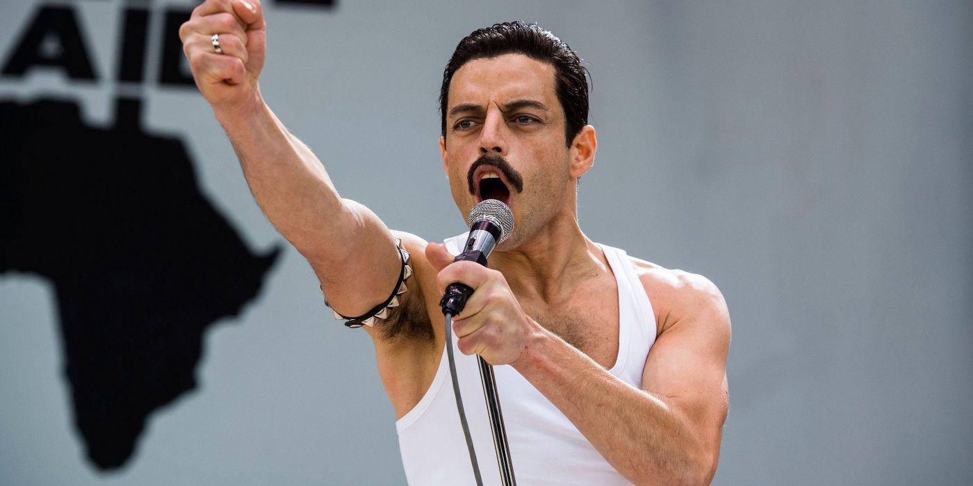 Rami Malek raising a hand in Live Aid in Bohemian Rhapsody