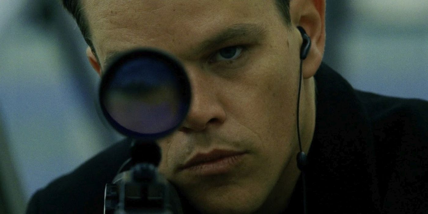 Jason Bourne melihat ke bawah teropong senapan penembak jitu