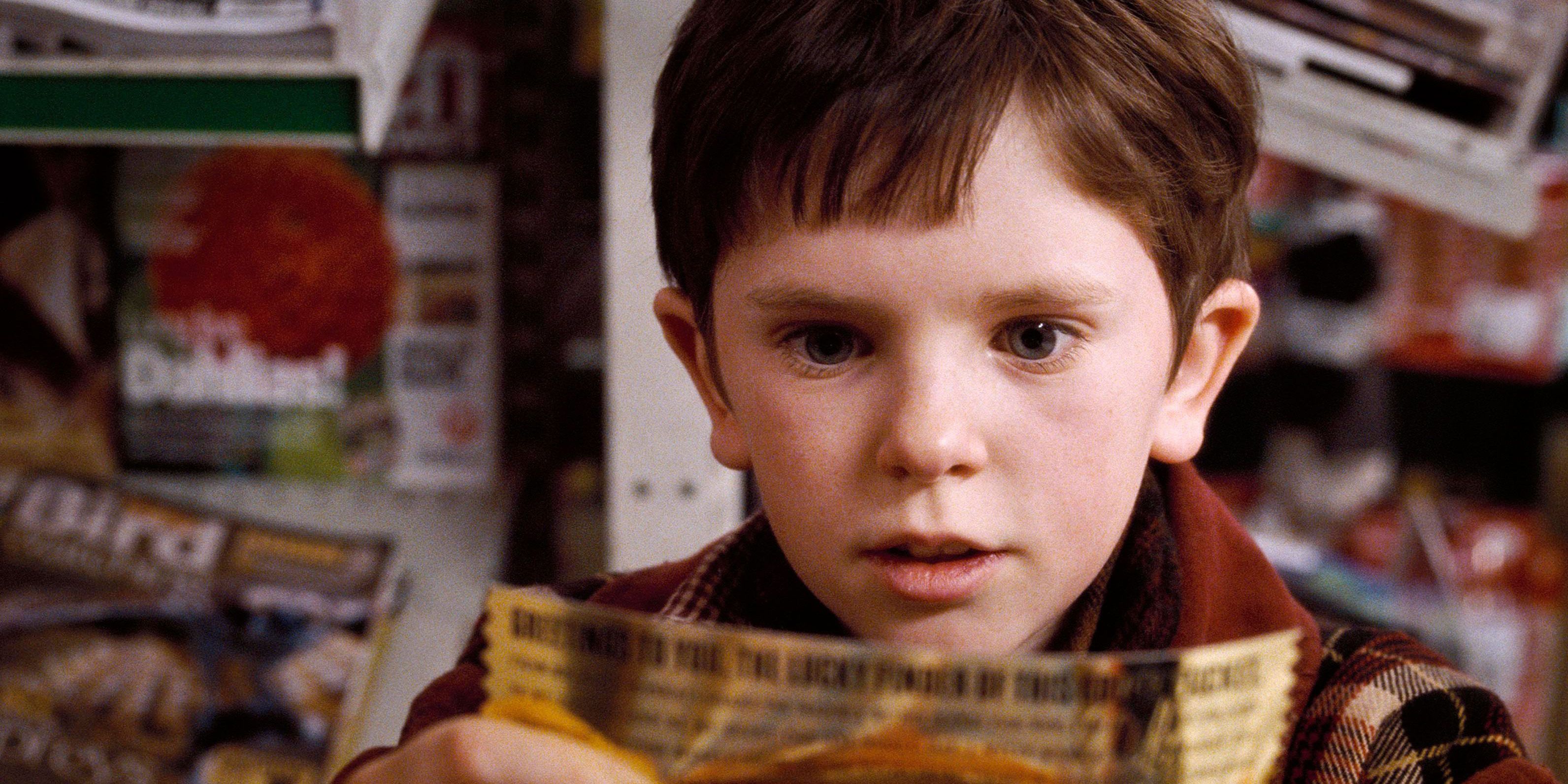 Charlie looking at his golden ticket in Charlie and the Chocolate Factory.