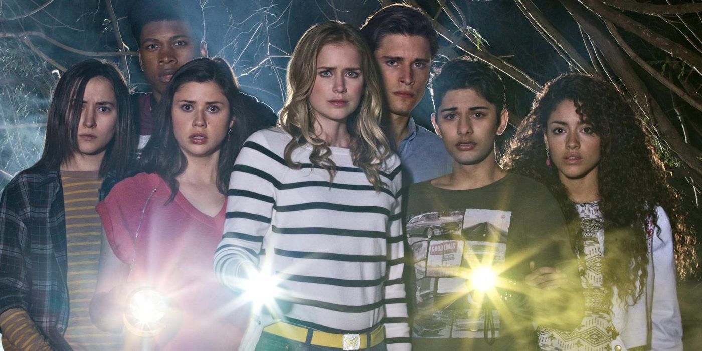 The cast of Dead of Summer standing together and holding torches 