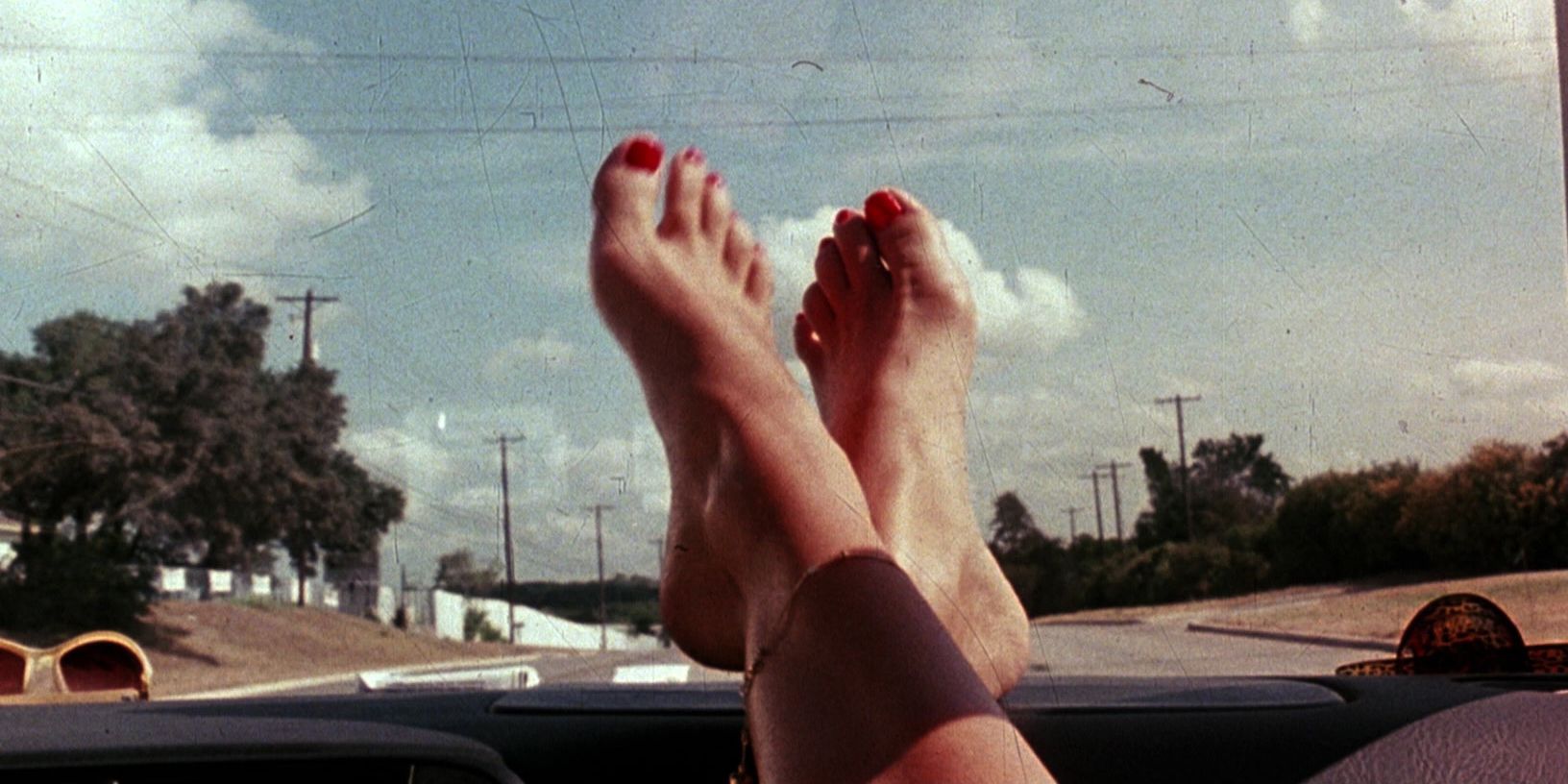 Les pieds sur le tableau de bord d'une voiture dans la scène d'ouverture de Death Proof