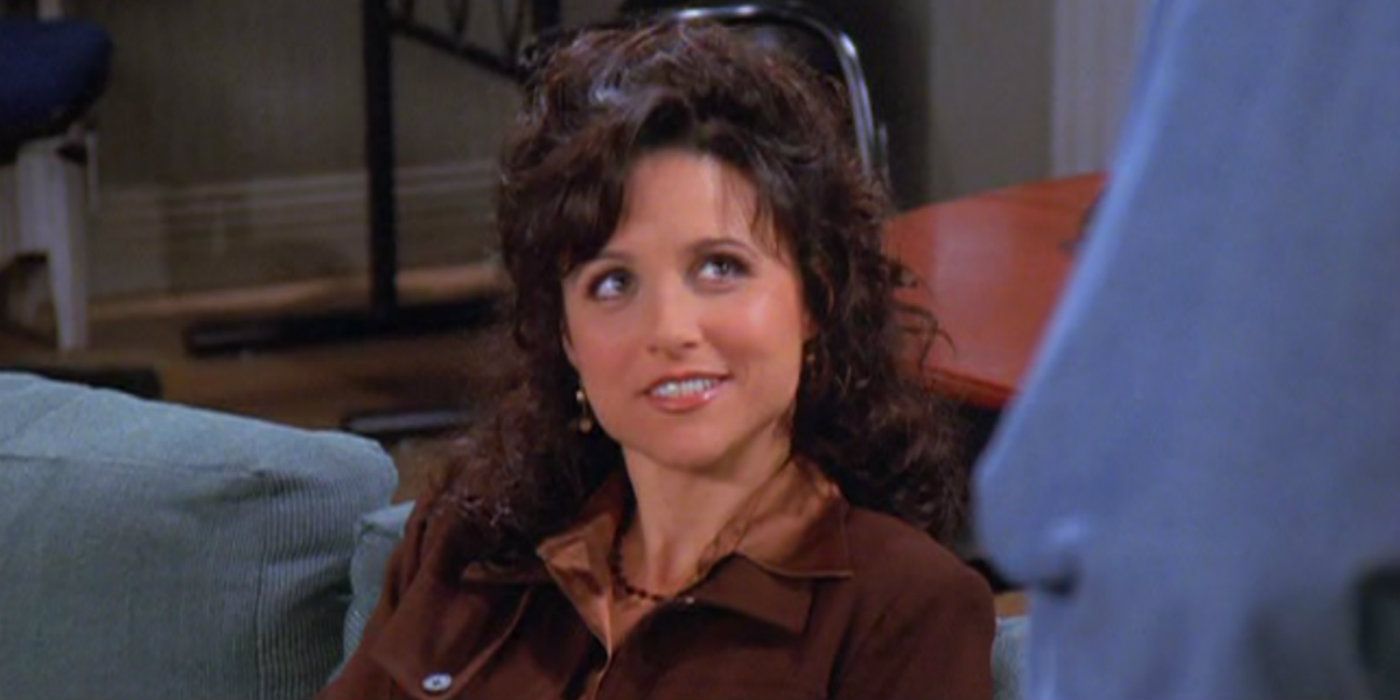Elaine smiling on Jerry's couch on Seinfeld