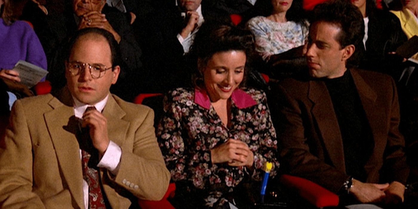 Elaine sitting with George and Jerry and laughing at a pez dispenser on Seinfeld