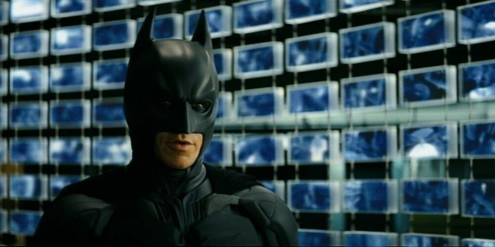 Batman in front of surveillance images in The Dark Knight