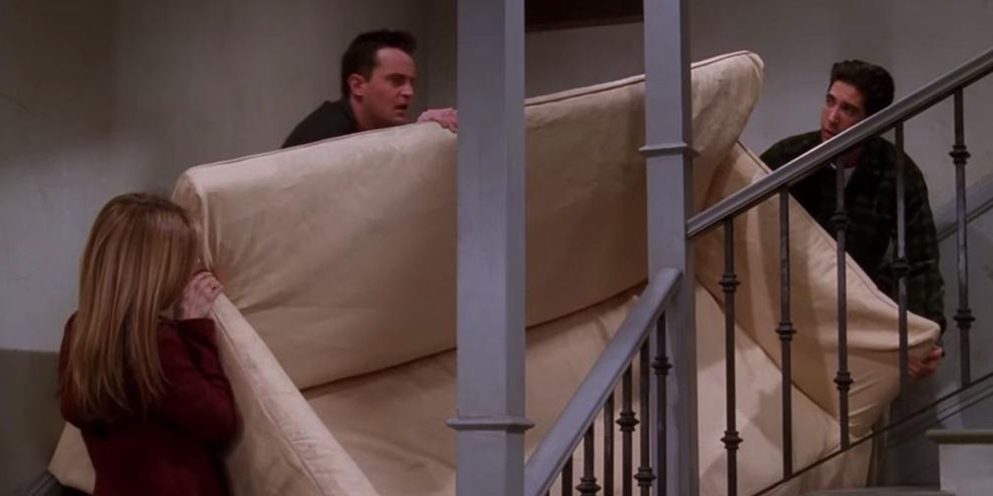Rachel e Chandler ajudam Ross a carregar seu sofá escada acima em Friends