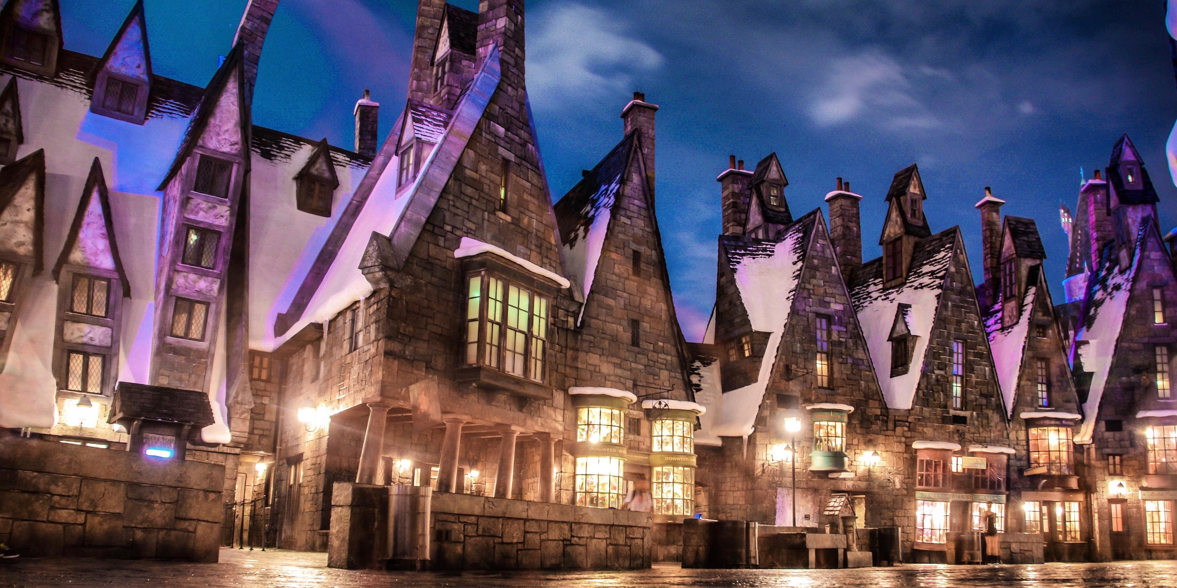 A view of Hogsmeade's cottages lit up at night in Harry Potter