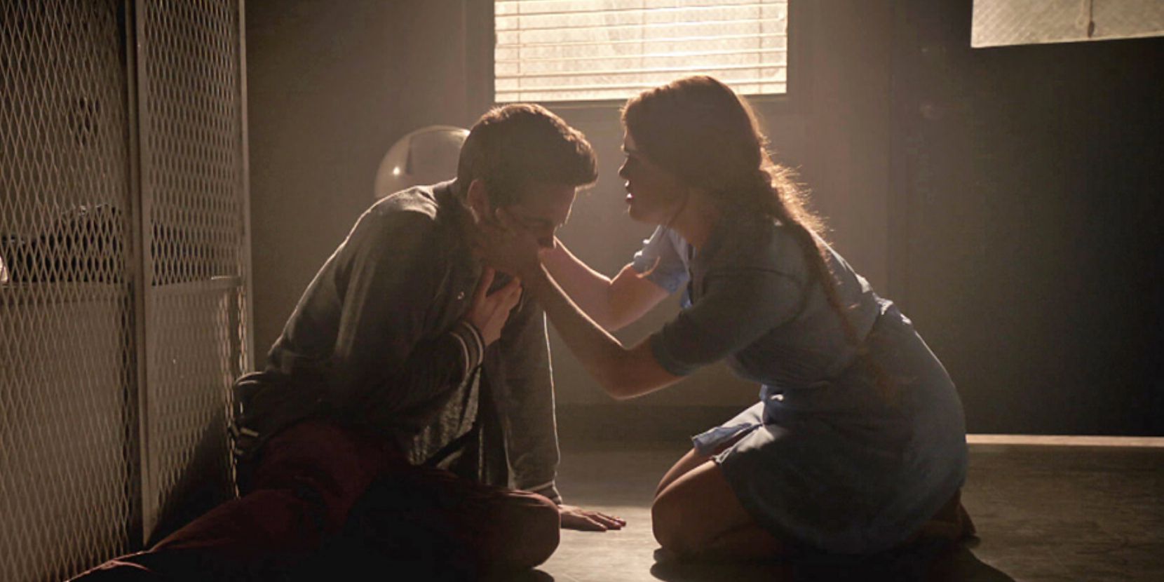 Stiles e Lydia se ajoelham no chão enquanto ela o ajuda a passar por um ataque de pânico em Teen Wolf
