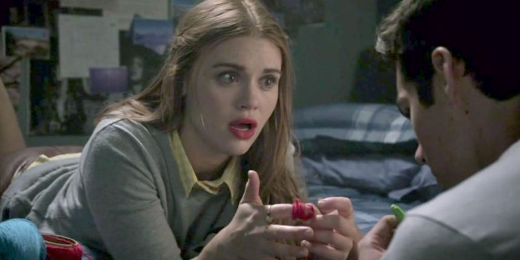 Lydia listens to Stiles while twisting red yarn in Teen Wolf