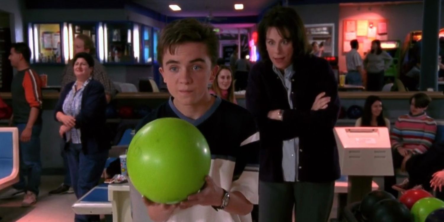 Malcolm holding a bright green bowling ball in a bowling alley in Malcolm In The Middle Bowling S2E20