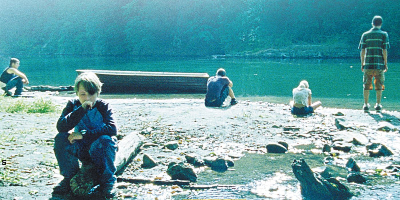 Crianças sentadas perto de um lago com um humor triste em um alambique de Mean Creek