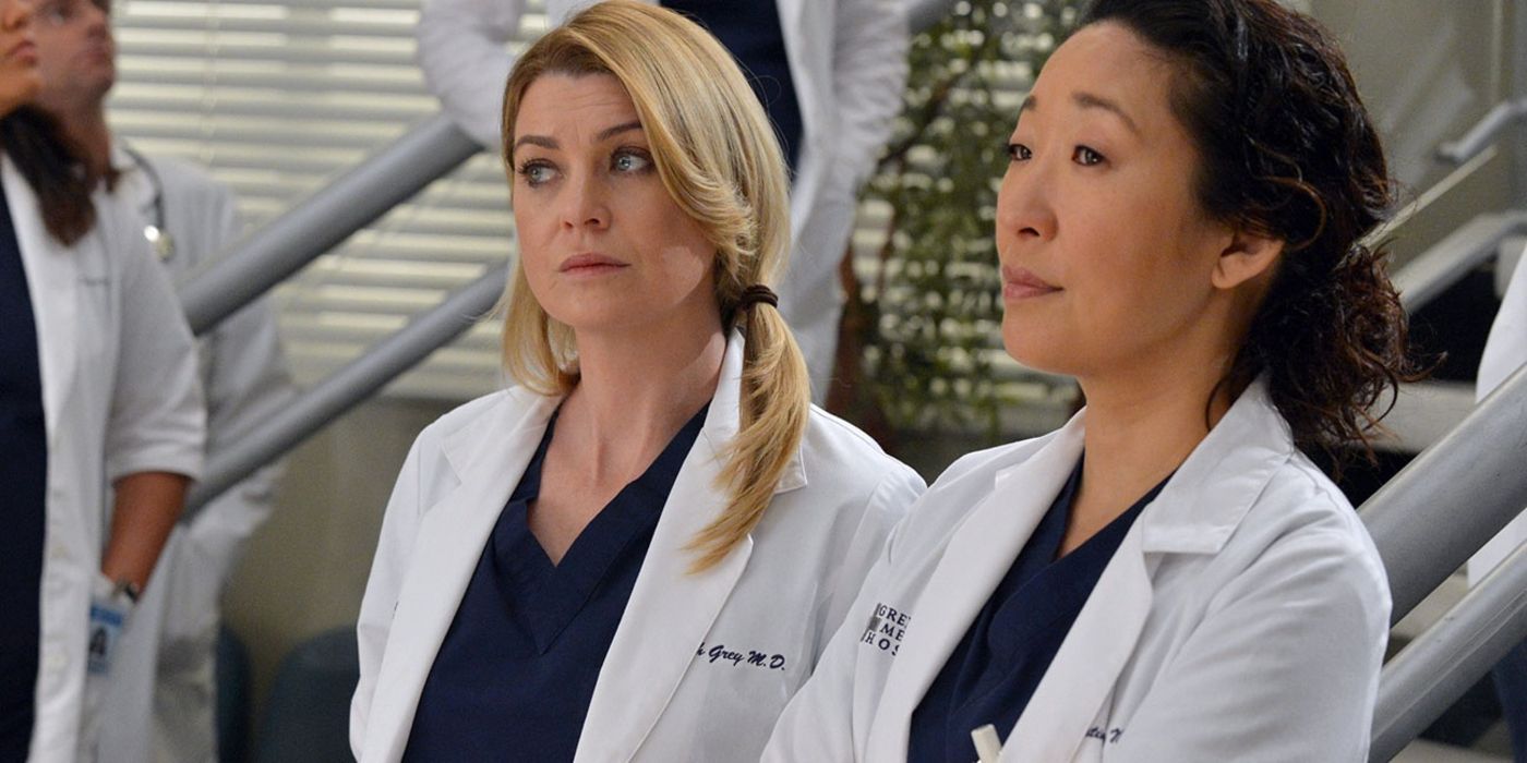 Meredith looks away as Cristina looks forward in Grey's Anatomy.