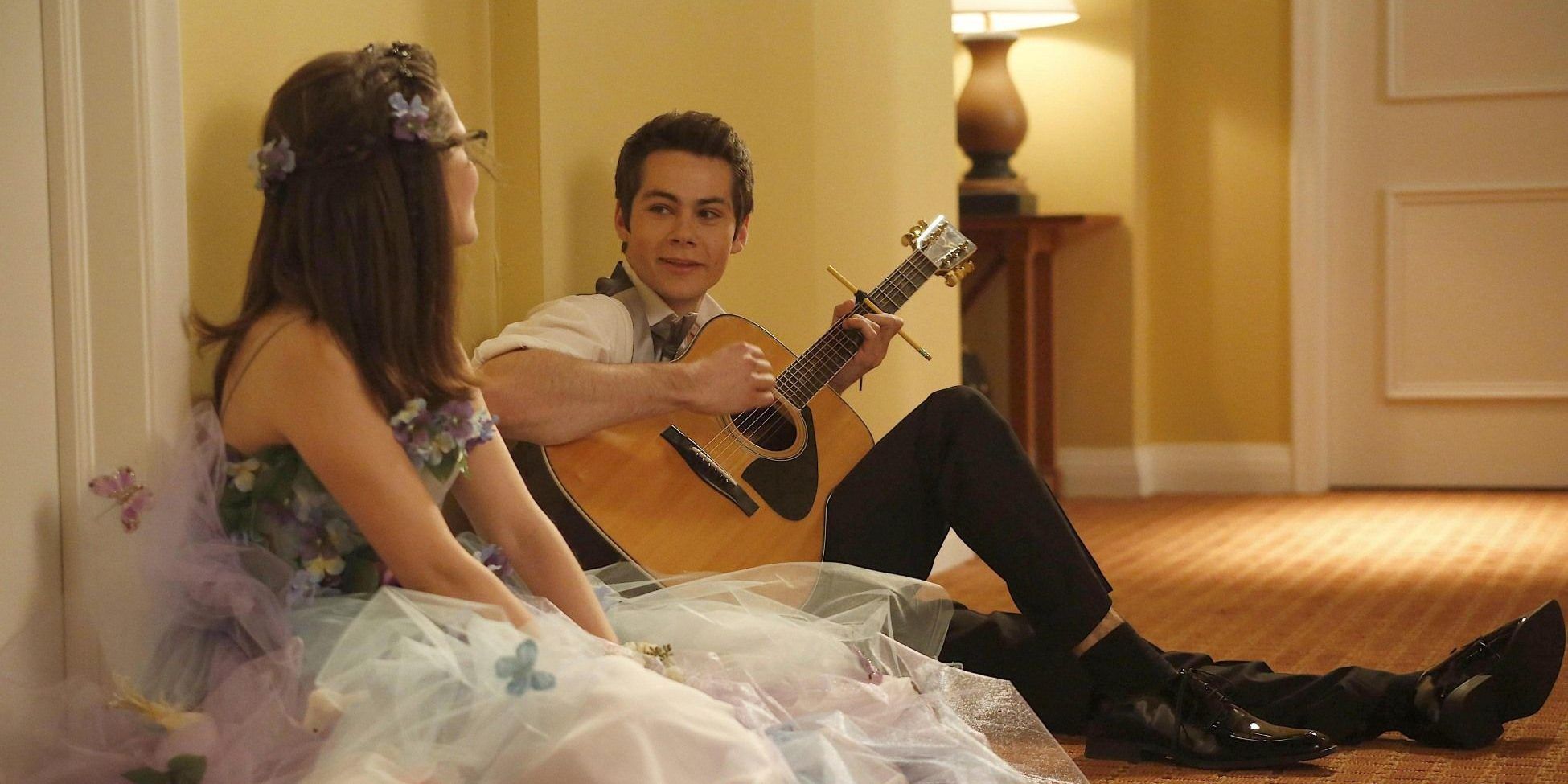 Zooey Deschanel and Dylan O'Brien on the floor of a hotel with a guitar in the New Girl episode Virgins