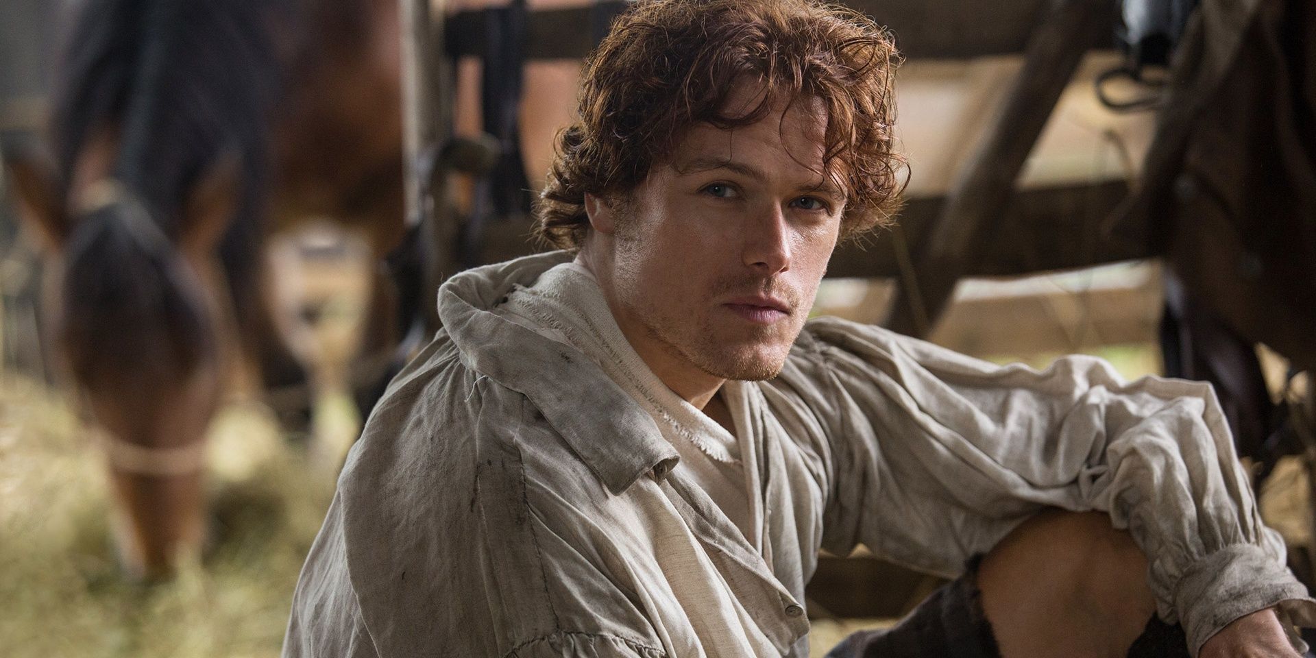 Jamie Fraser in white shirt looking into the camera Outlander