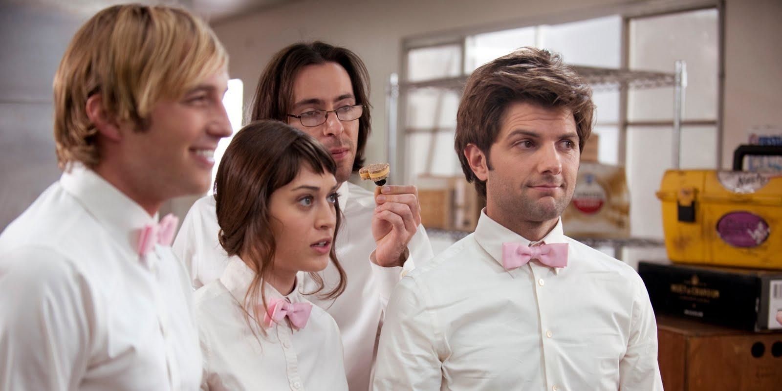4 waiters in white outfits look on in Party Down.