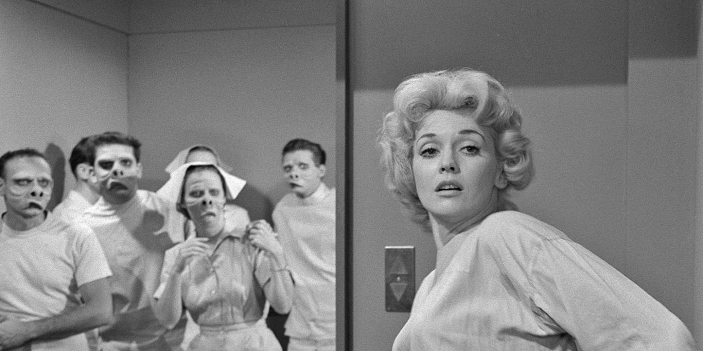 Still from the Twilight Zone episode The Eye of the Beholder of a woman being looked at by doctors and nurses with contorted faces