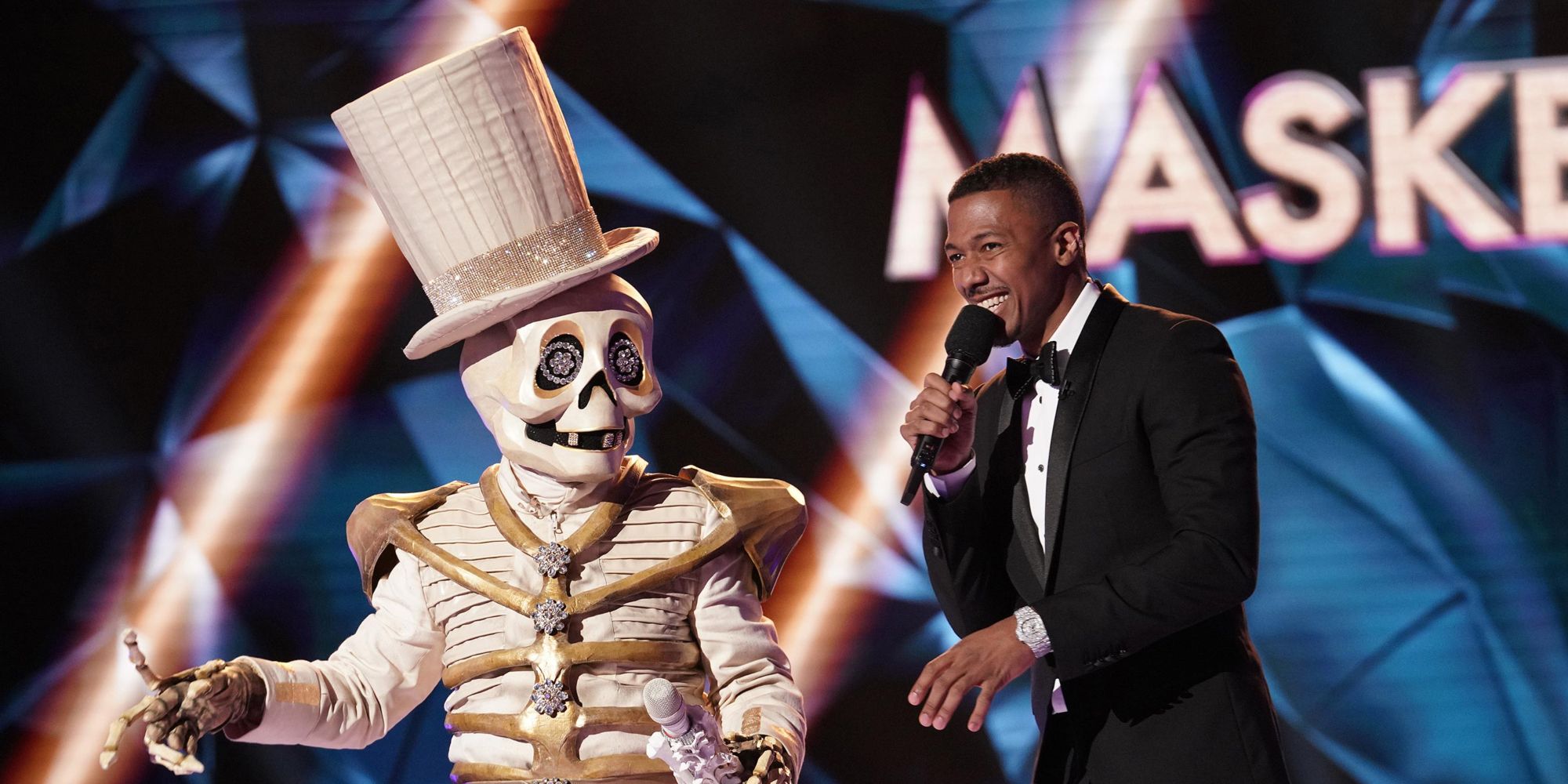 The Masked Singer Season 2 The Skeleton standing next to the host