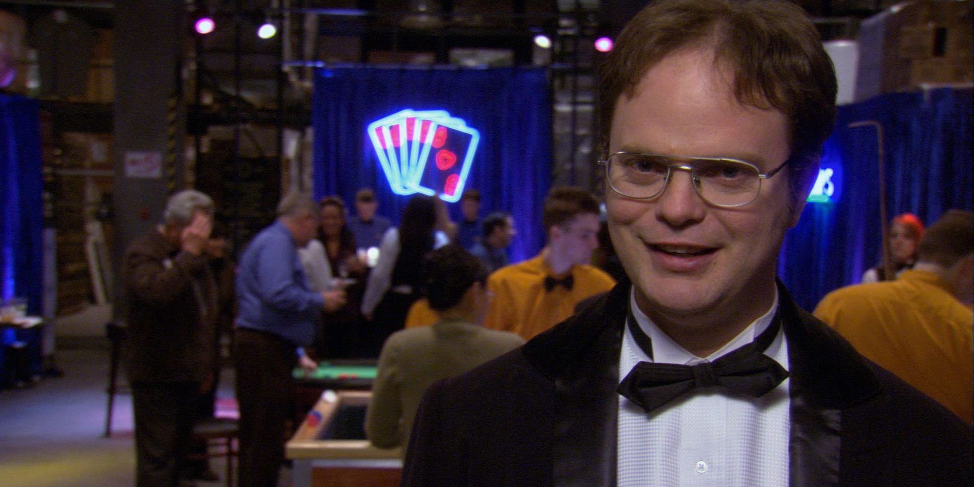 Dwight (Rainn Wilson) grinning in a tuxedo during casino night in The Office