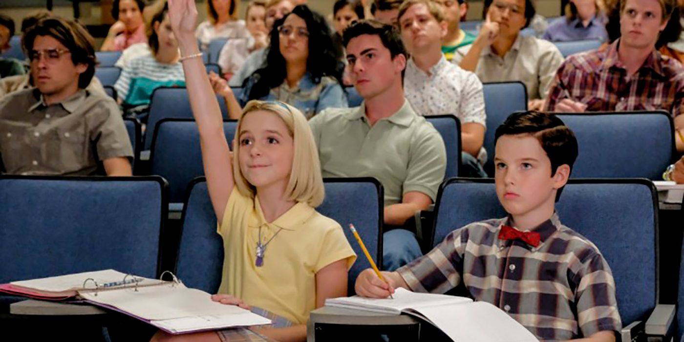 Paige and Sheldon in class from Young Sheldon, Paige enthusiastically raising her hand.