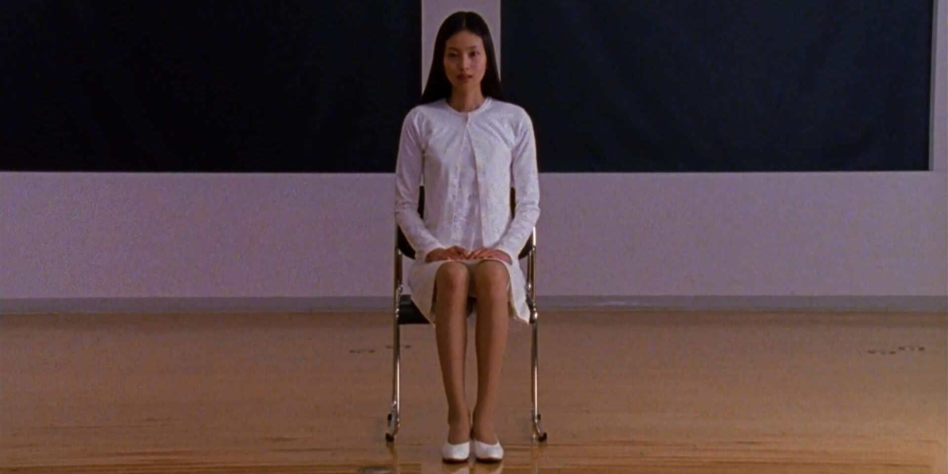 Asami sitting in a chair in Audition