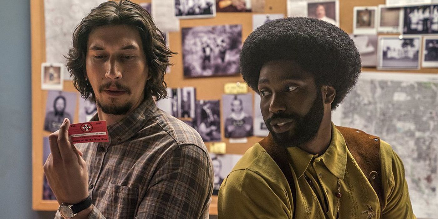 Two men stand back to back and look at each other in BlacKkKlansman.