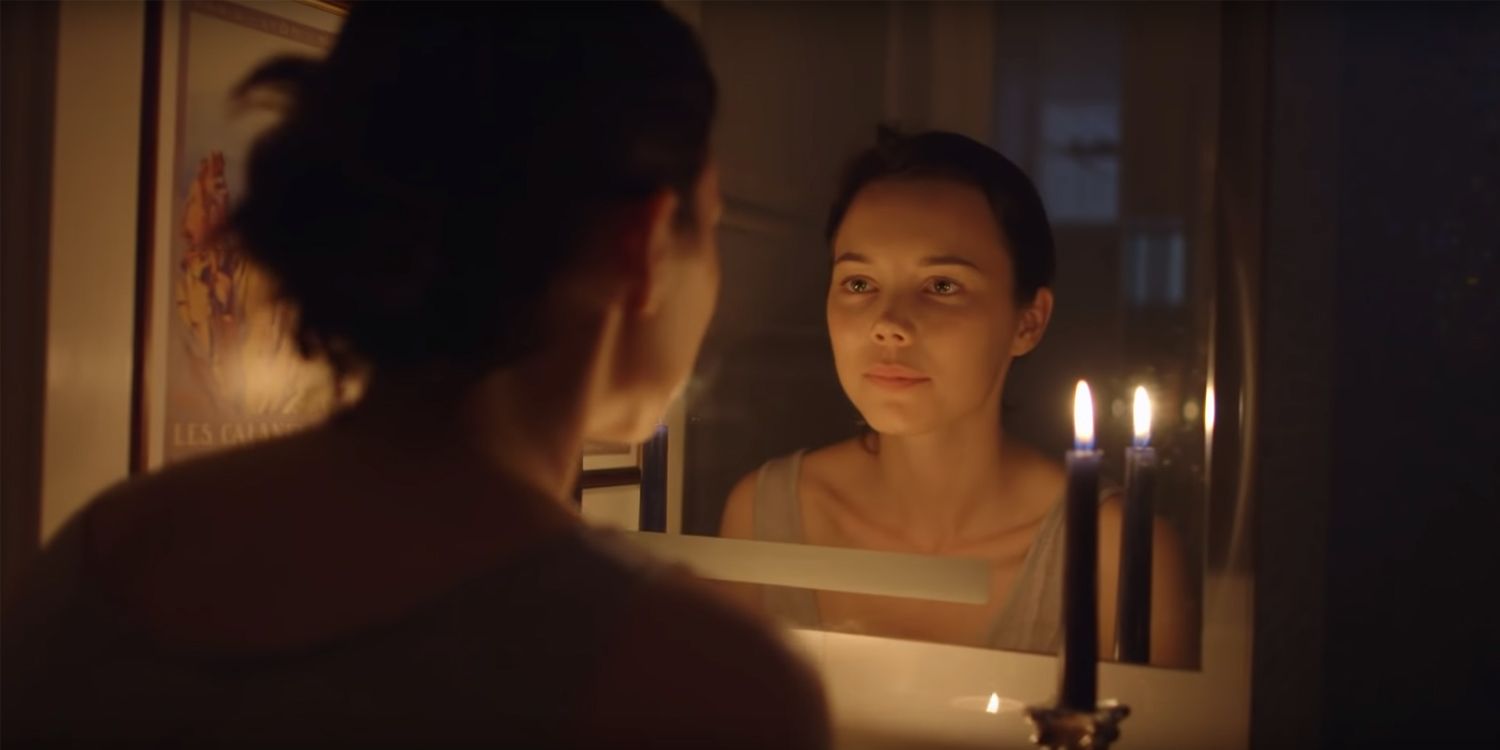 A girl stares in the mirror in the horror short film Bloody Mary