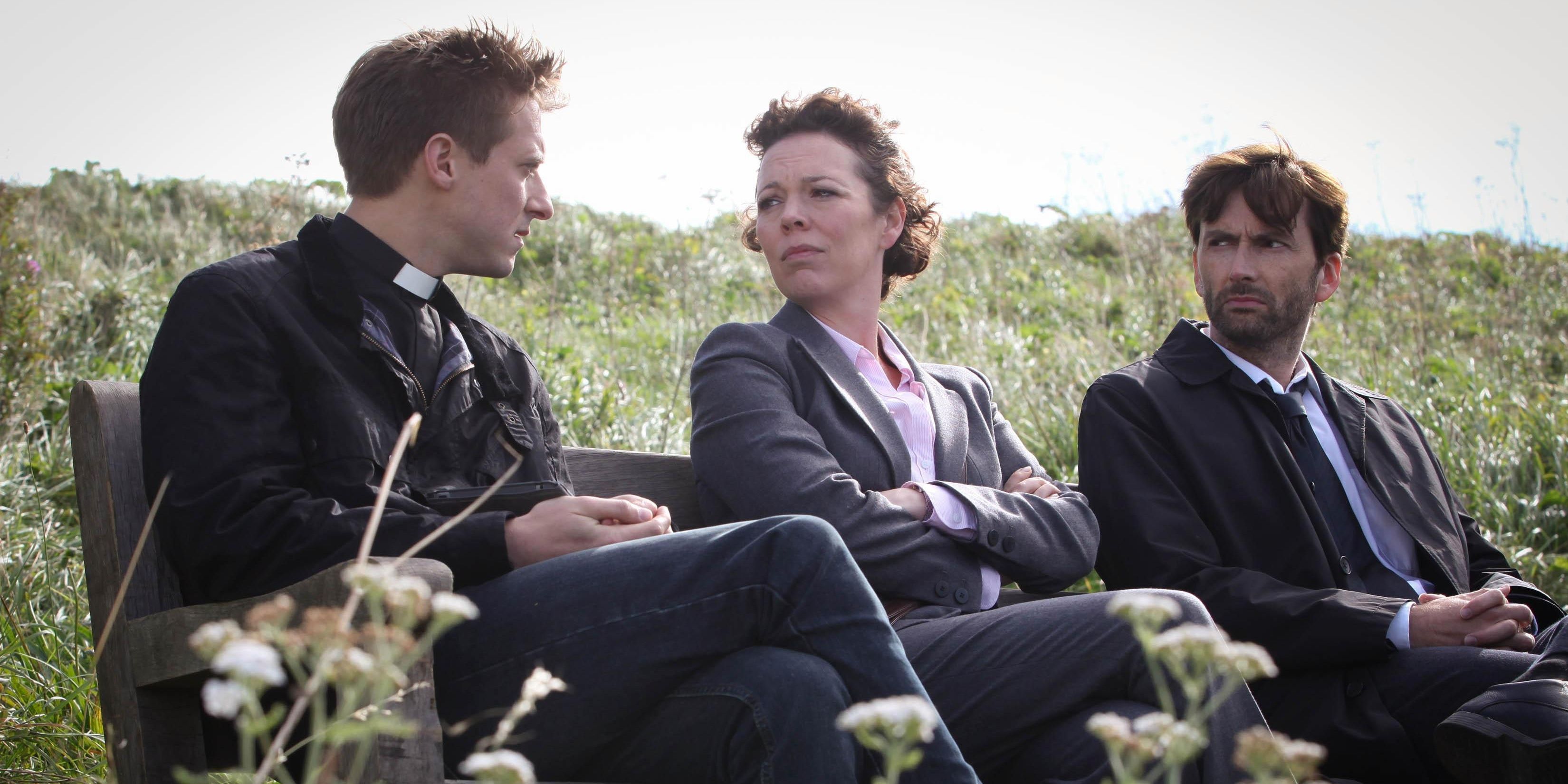 David Tenant and Olivia Colman speak with a priest outside in Broadchurch