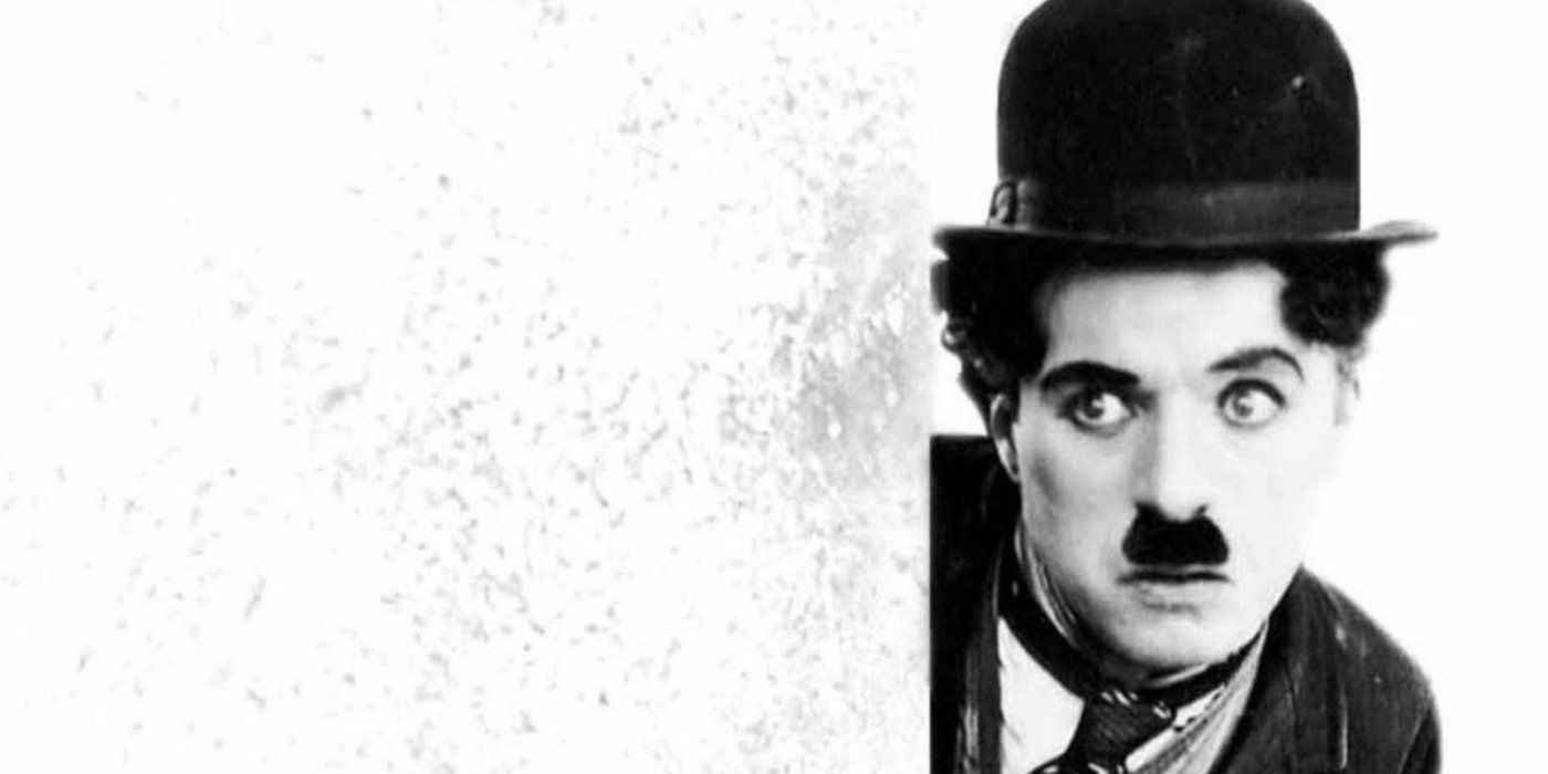 Charlie Chaplin peeks around a corner as the Tramp character 