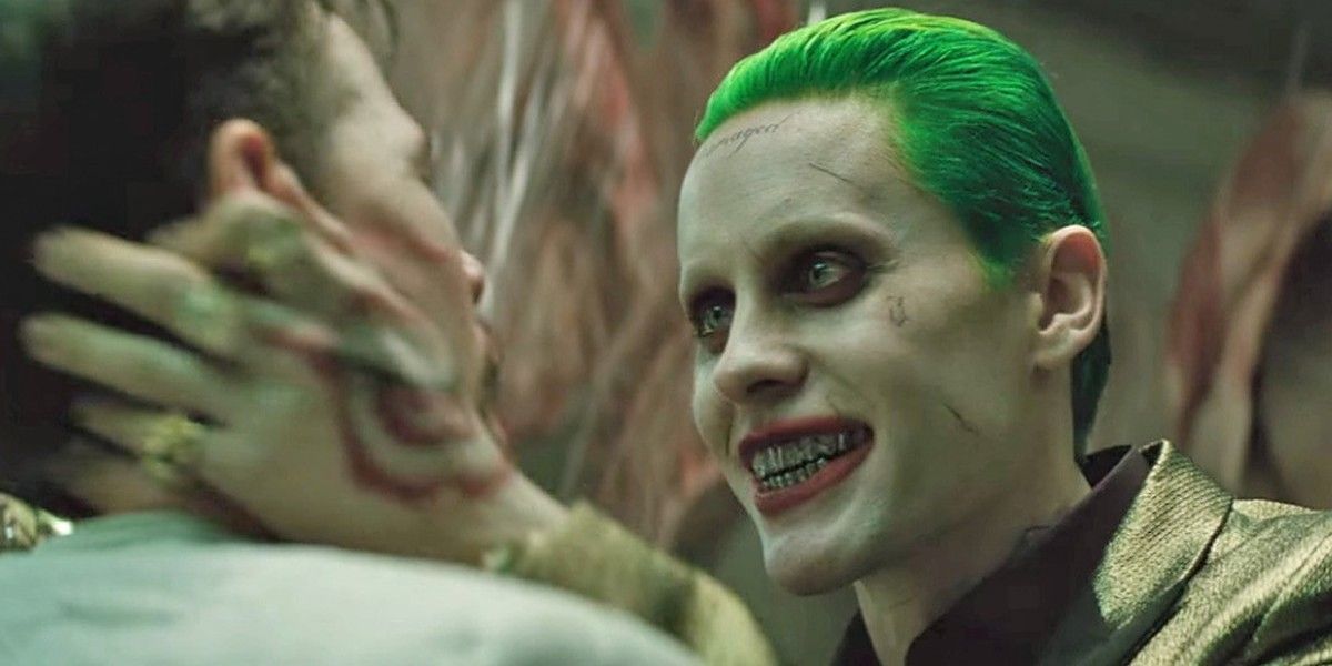 Joker holds victims face menacingly in Suicide Squad