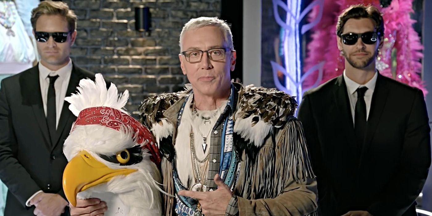 Dr. Drew as the Eagle with two men in black suits in The Masked Singer